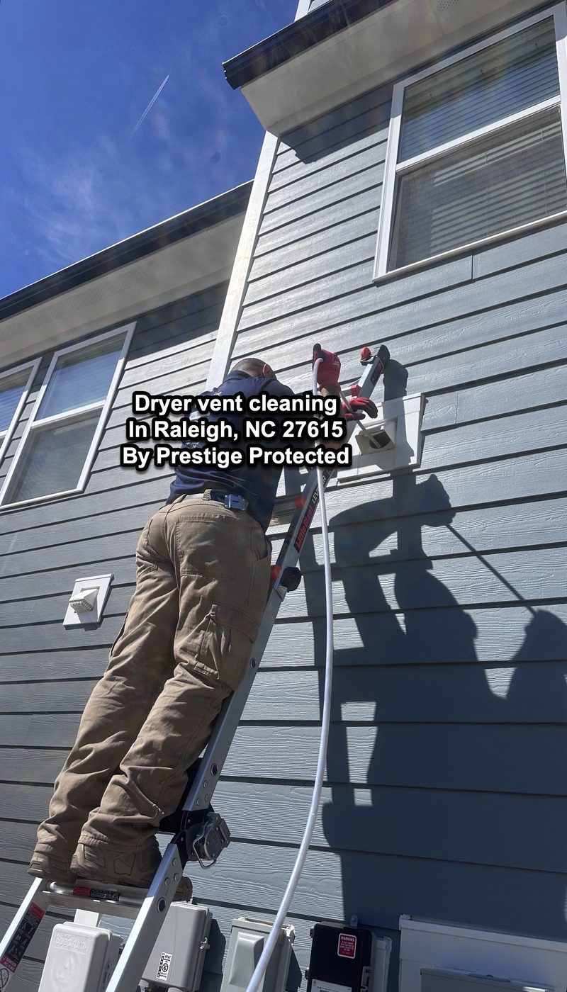 Prestige Protected technician cleaning a second-story dryer vent on a two-story home in Raleigh, NC 27615