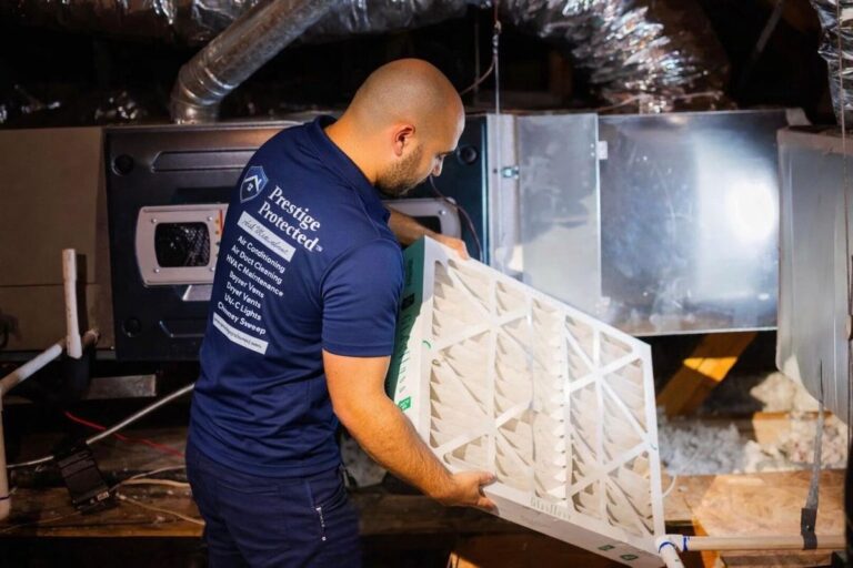 Prestige Protected technician servicing an HVAC air handler in a home attic