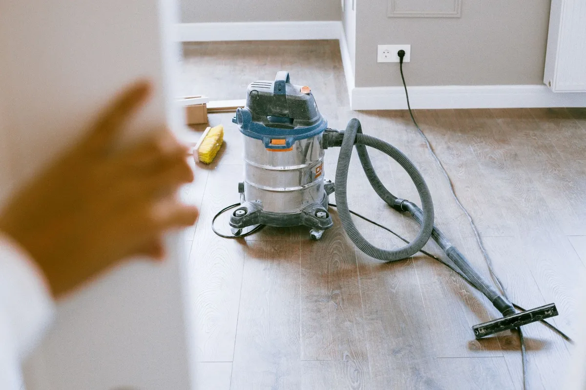 An industrial vacuum cleaner in a renovated apartment, ready for air duct cleaning preparation.
