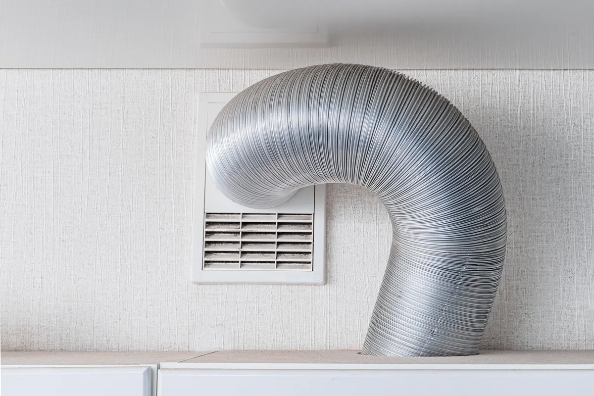 A modern kitchen with a ventilation hood and exhaust system, relevant to air duct cleaning considerations.